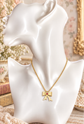 Gold-tone bow pendant necklace with red crystal